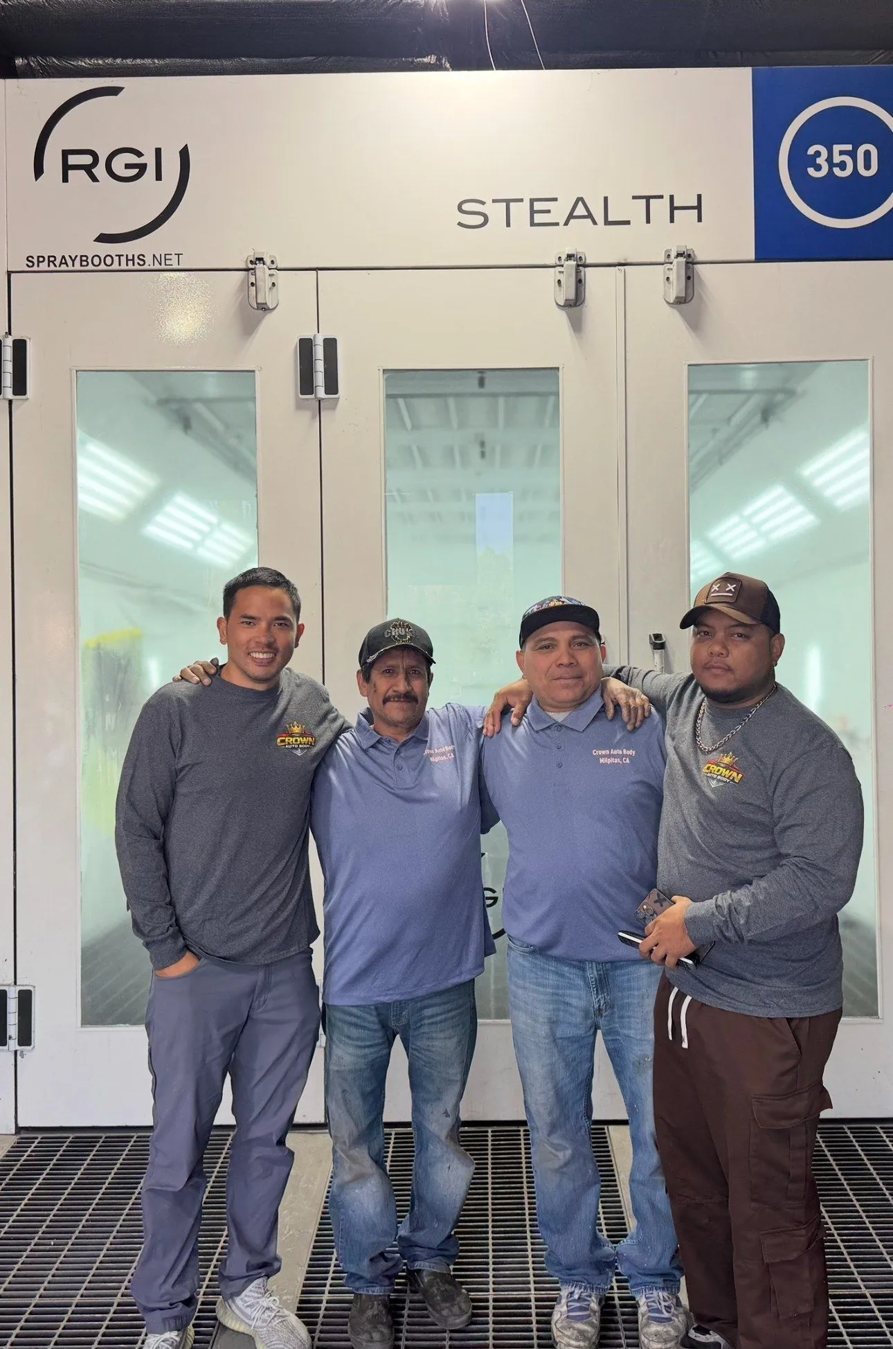 The Crown Auto Body team in front of their professional spray booth